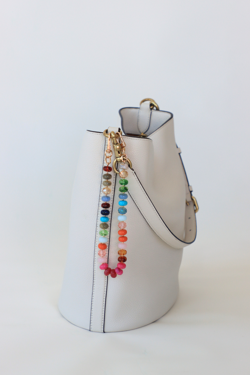 White bucket bag with colorful bead details on a white background