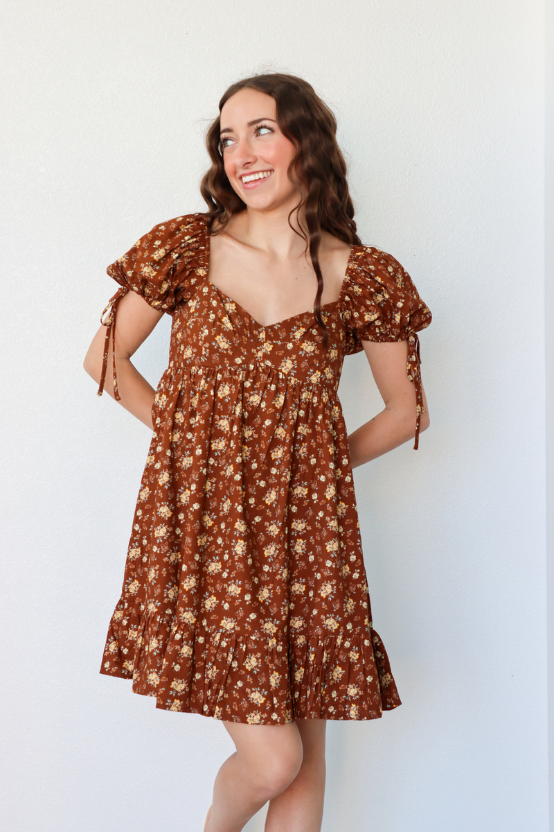 girl wearing short brown floral dress