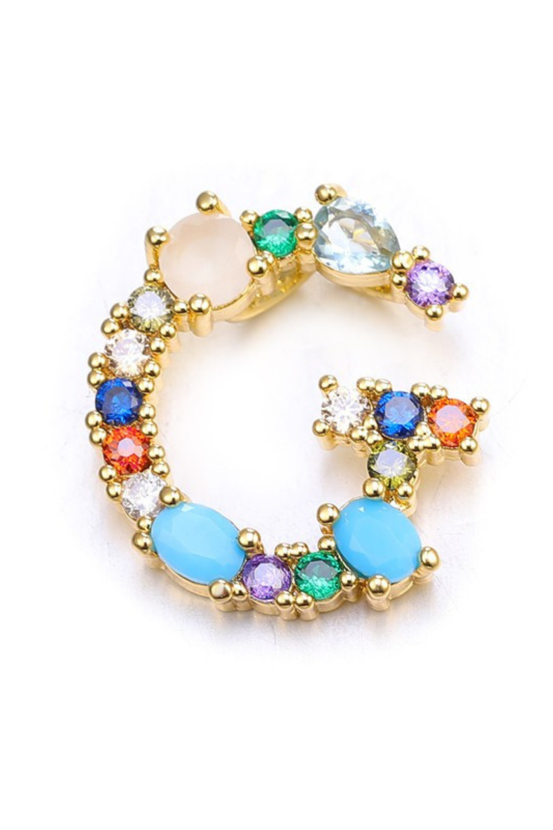 Multicolored gemstone ring with gold band on a white background