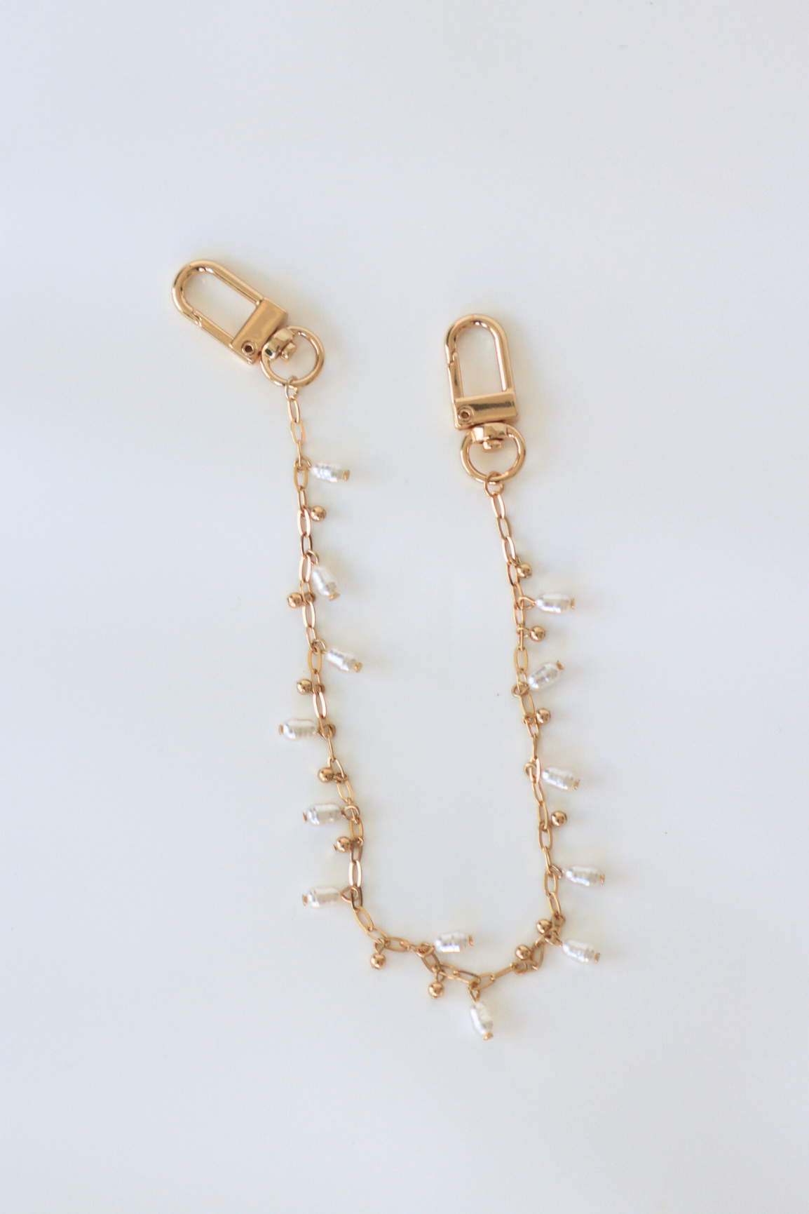 Gold chain with small beads on a white background