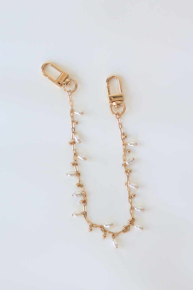 Gold chain with small beads on a white background