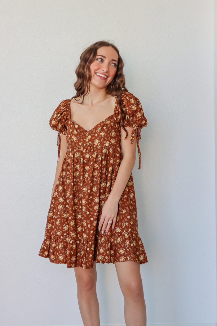 girl wearing short brown floral dress