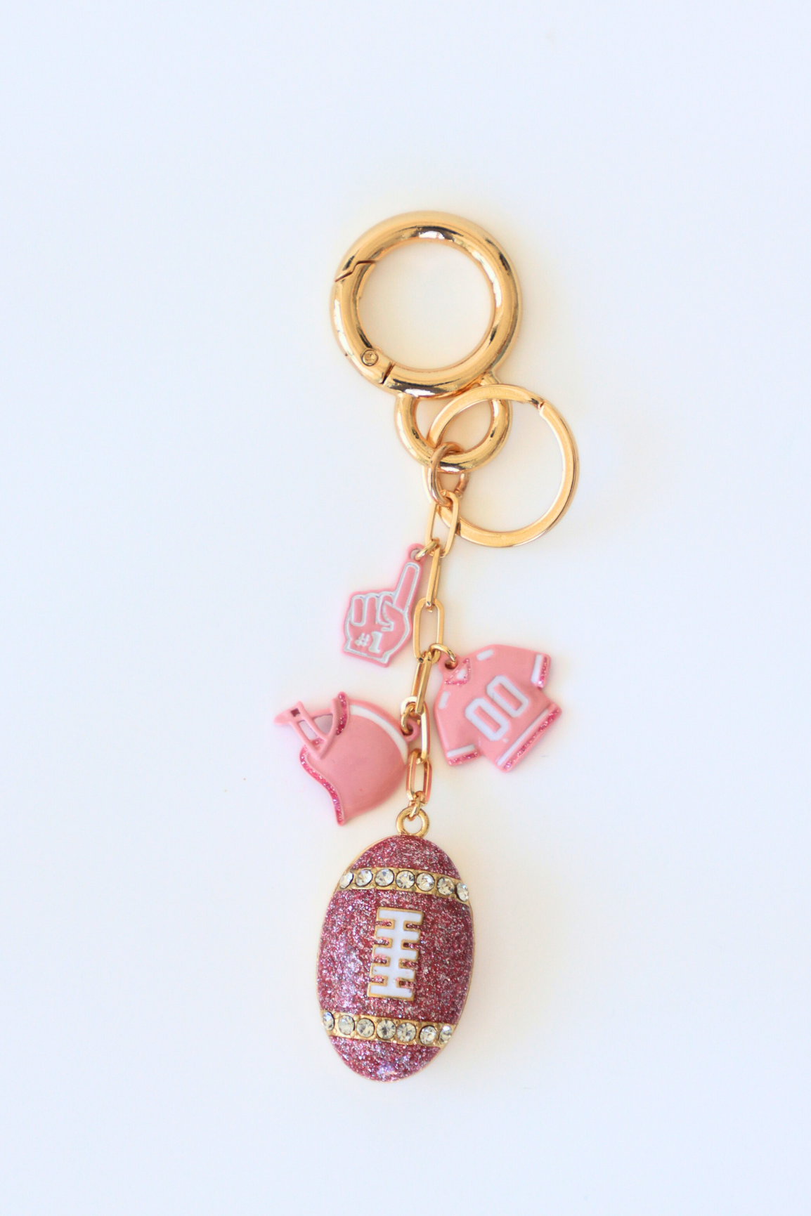 Pink glittery football keychain with pink heart and 'LOVE' keychain on a white background