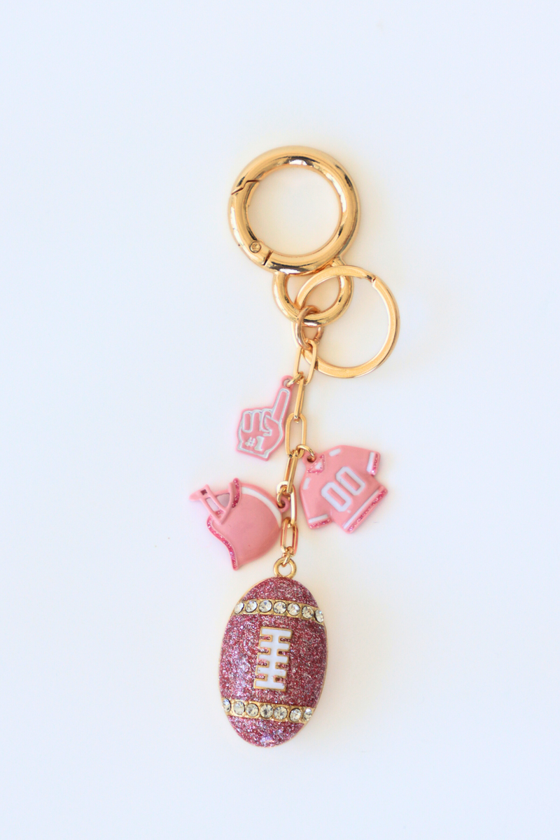 Pink glittery football keychain with pink heart and 'LOVE' keychain on a white background