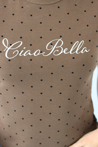 Close-up of a taupe-brown sheer mesh top with black polka dots and 'Ciao Bella' printed in white script across the chest.