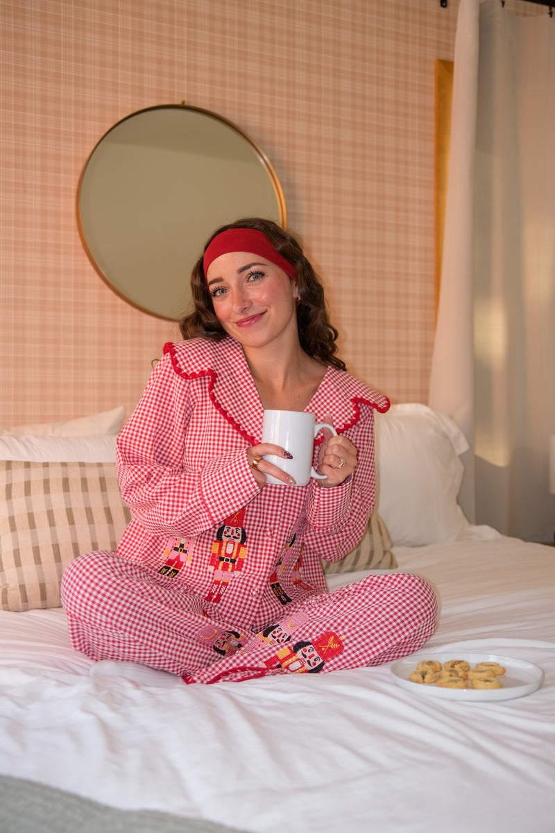 Woman wearing a red checkered pajama set with embroidered characters