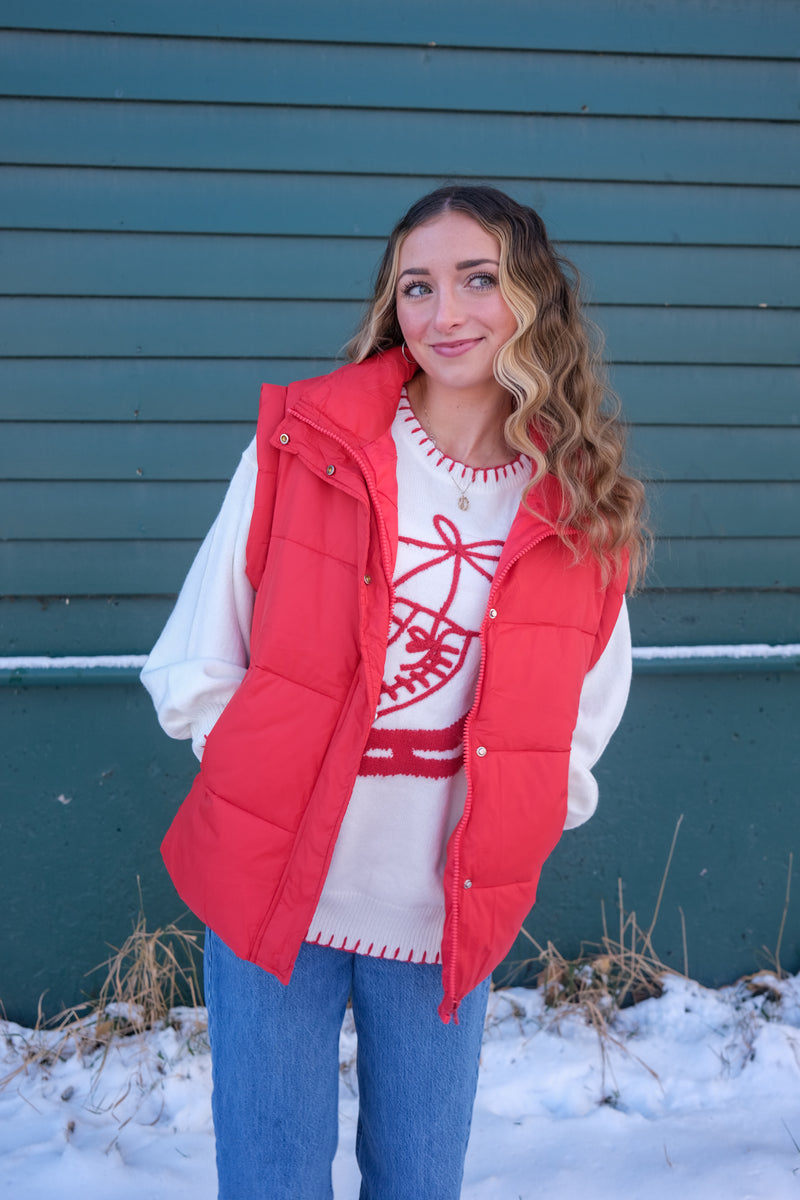 Woman wearing a white sweater with red ice skate design