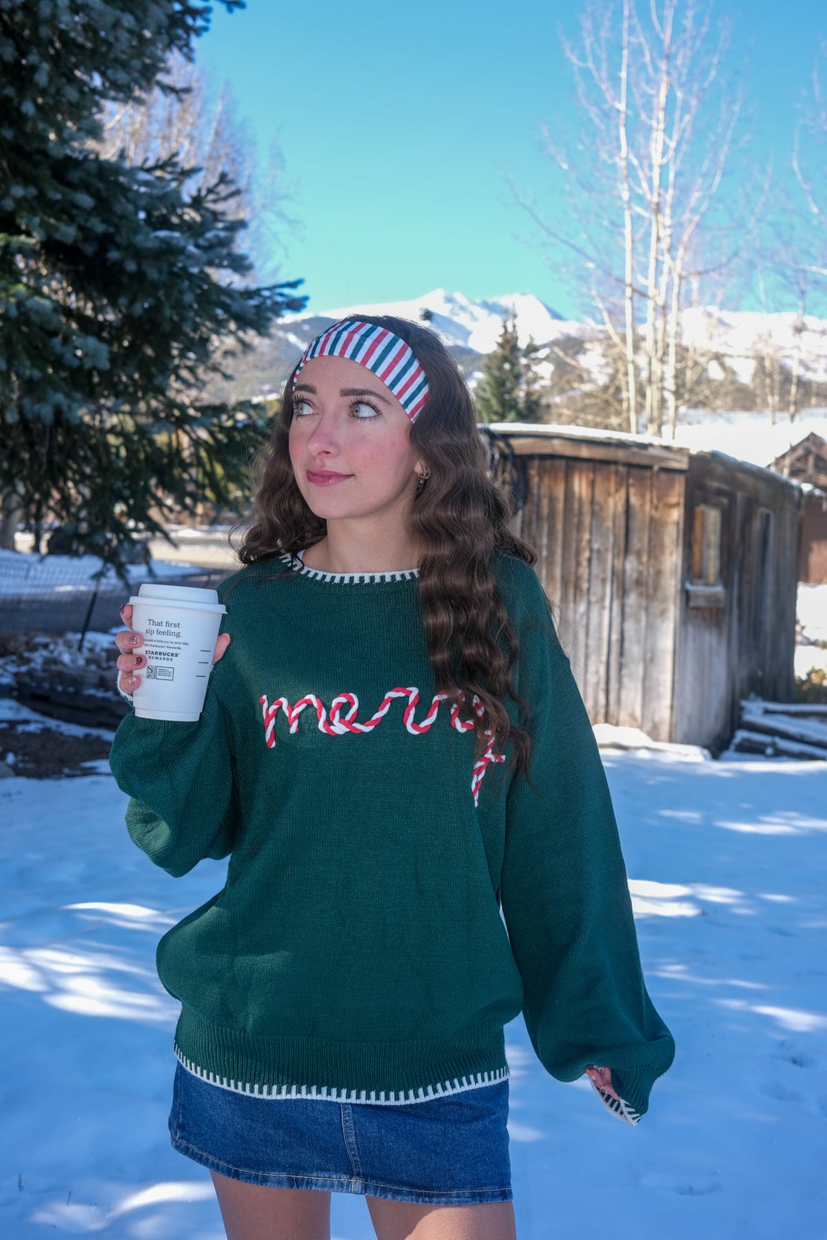 Woman wearing a green sweater with red text 
