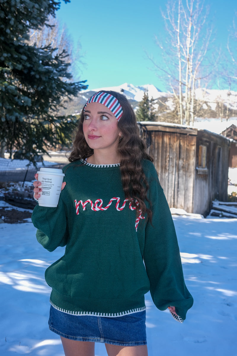 Woman wearing a green sweater with red text 