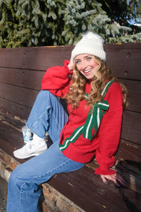 Person wearing a red sweater with a green ribbon design