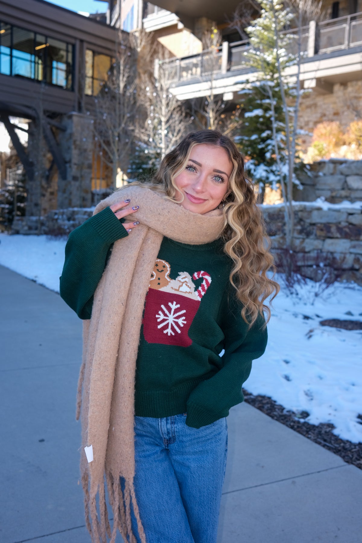 girl wearing dark green knit sweater with hot cocoa graphic