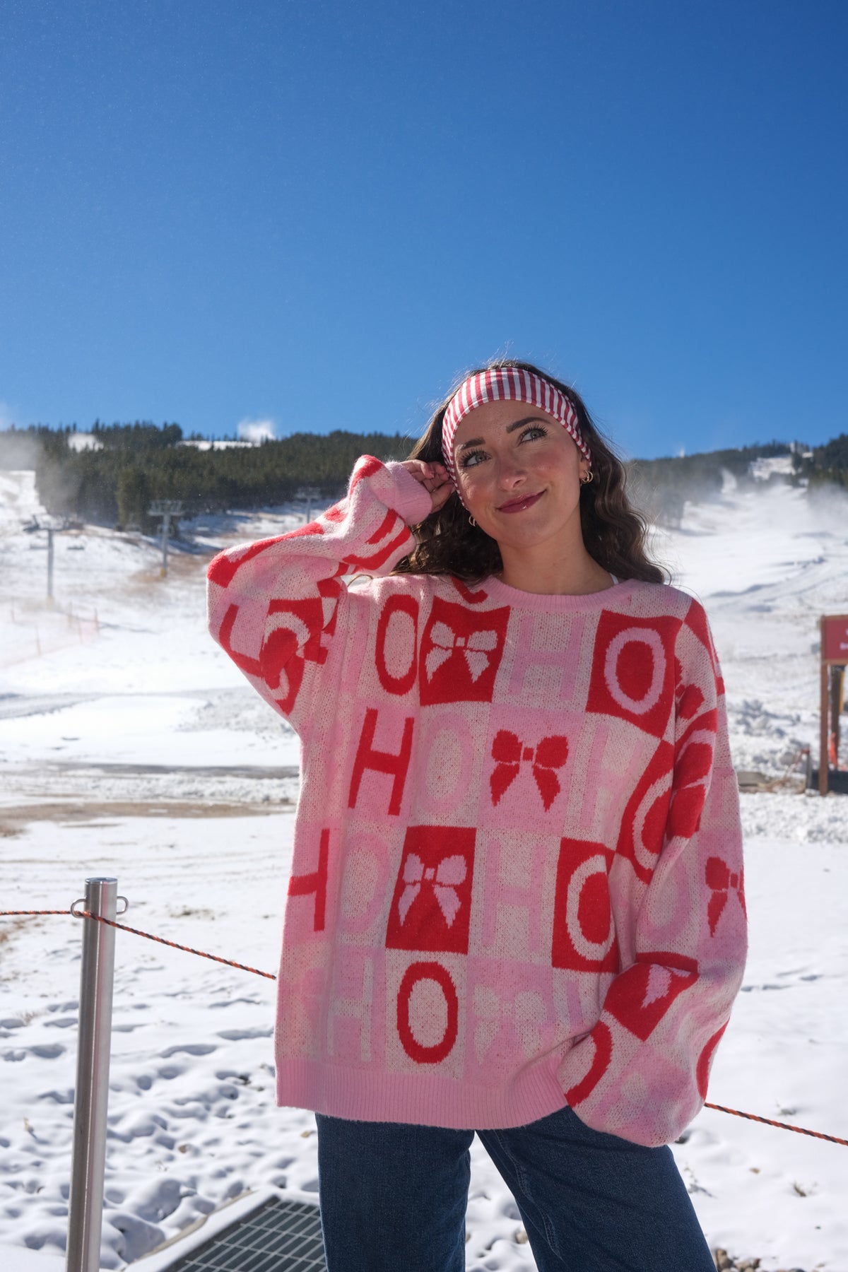 Person wearing a pink sweater with red patterns 