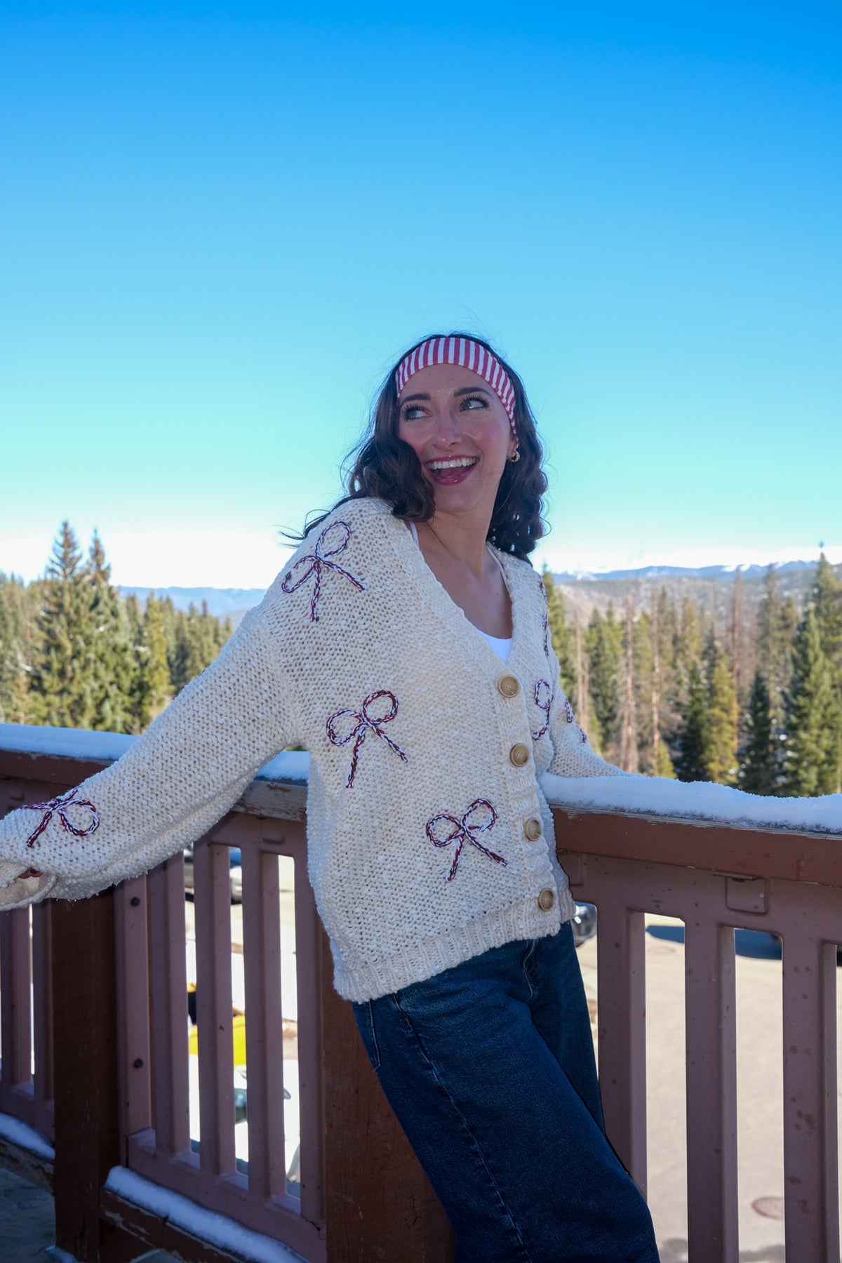 Woman wearing a cream cardigan with bow patterns