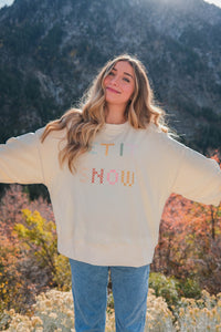 girl wearing cream "let it snow" top