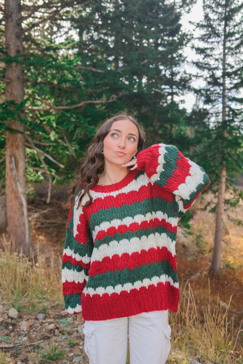 girl wearing red, green, and white knit sweater