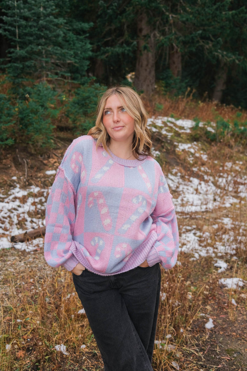 girl wearing periwinkle and pink candy cane sweater