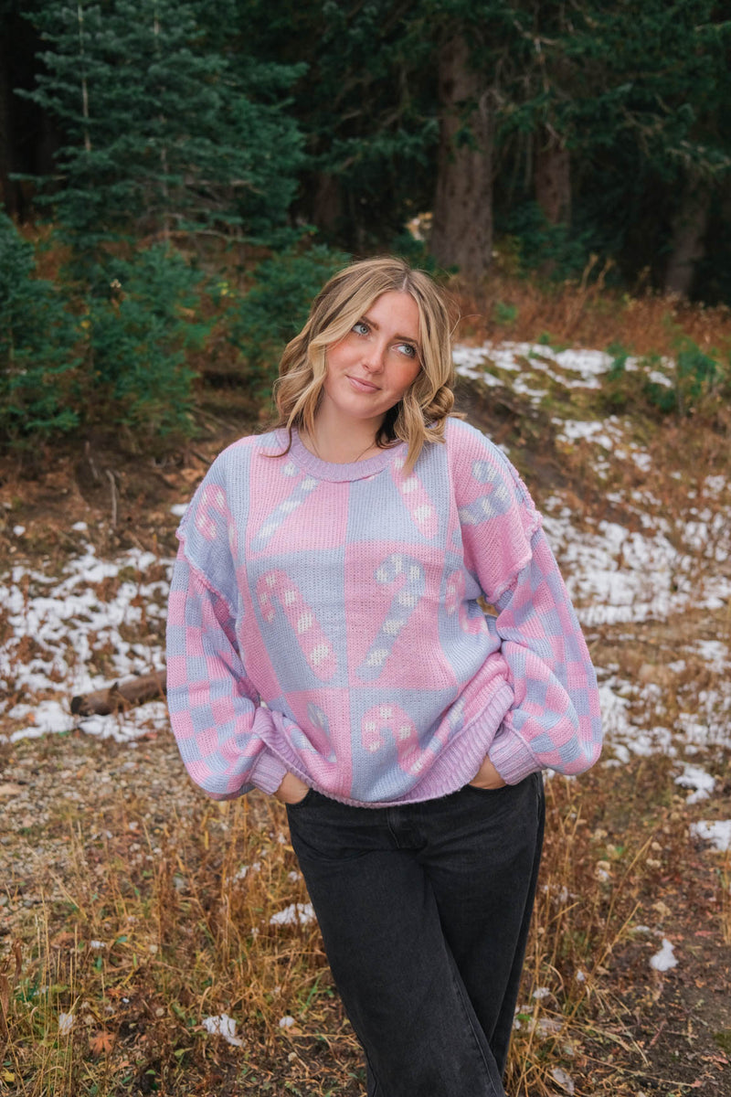 girl wearing periwinkle and pink candy cane sweater