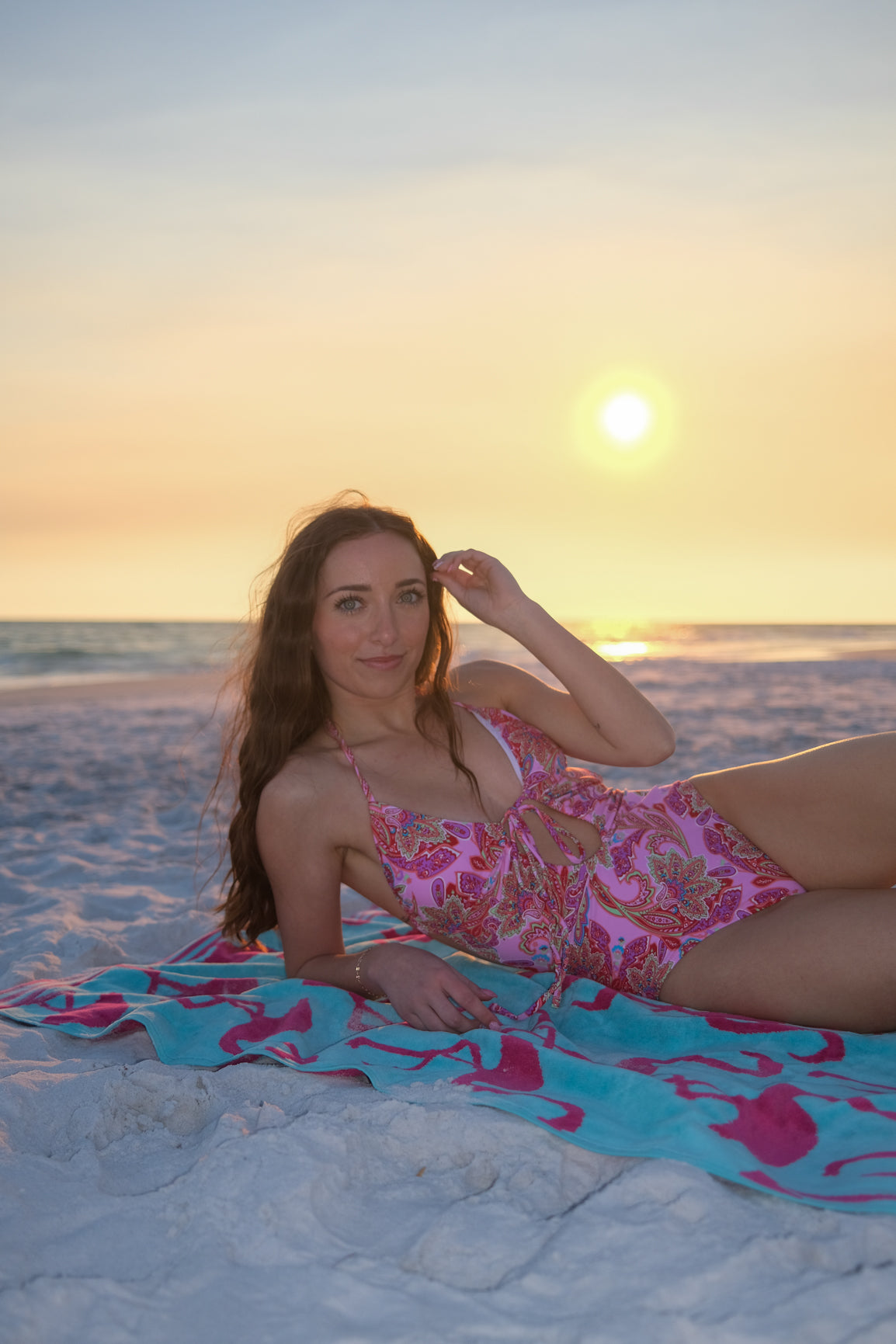 girl wearing pink patterned one piece swimsuit