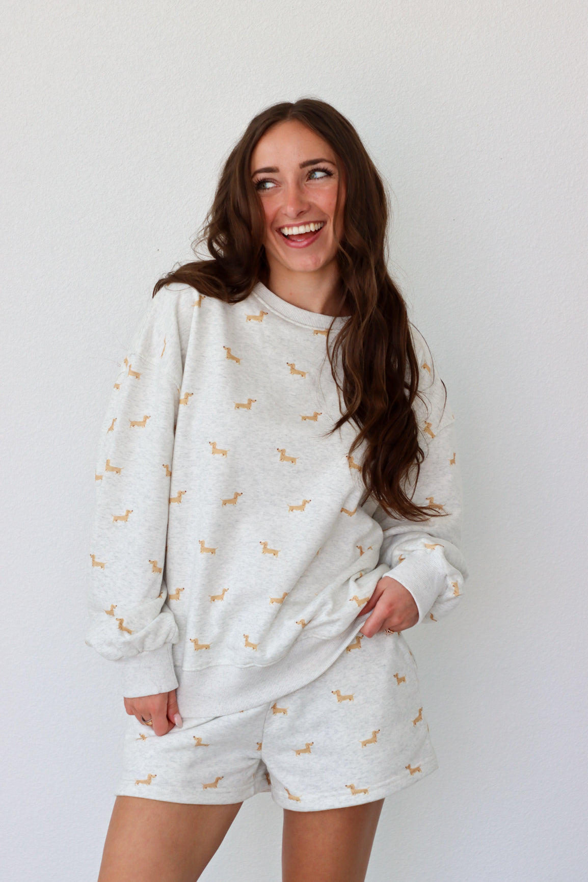 Woman wearing a light gray set with small patterns on a white background