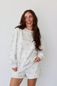 Woman wearing a light gray set with small patterns on a white background