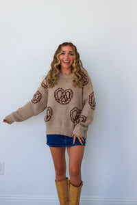 girl wearing tan and brown soft pretzel sweater