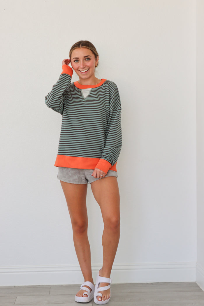 girl wearing teal striped top with orange hem detailing