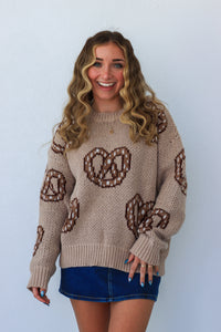 girl wearing tan and brown soft pretzel sweater