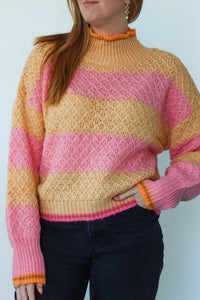 girl wearing pink and orange knit striped sweater