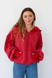 Woman wearing a red pullover with a white background