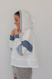 girl wearing white hoodie with blue sleeve detailing