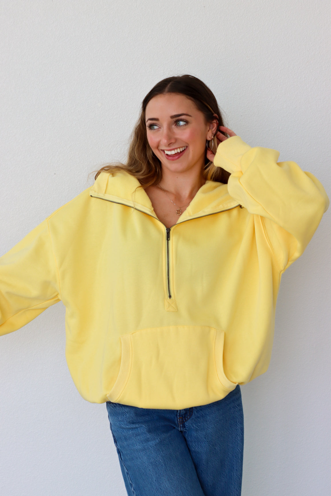 Woman wearing a yellow jacket against a white background