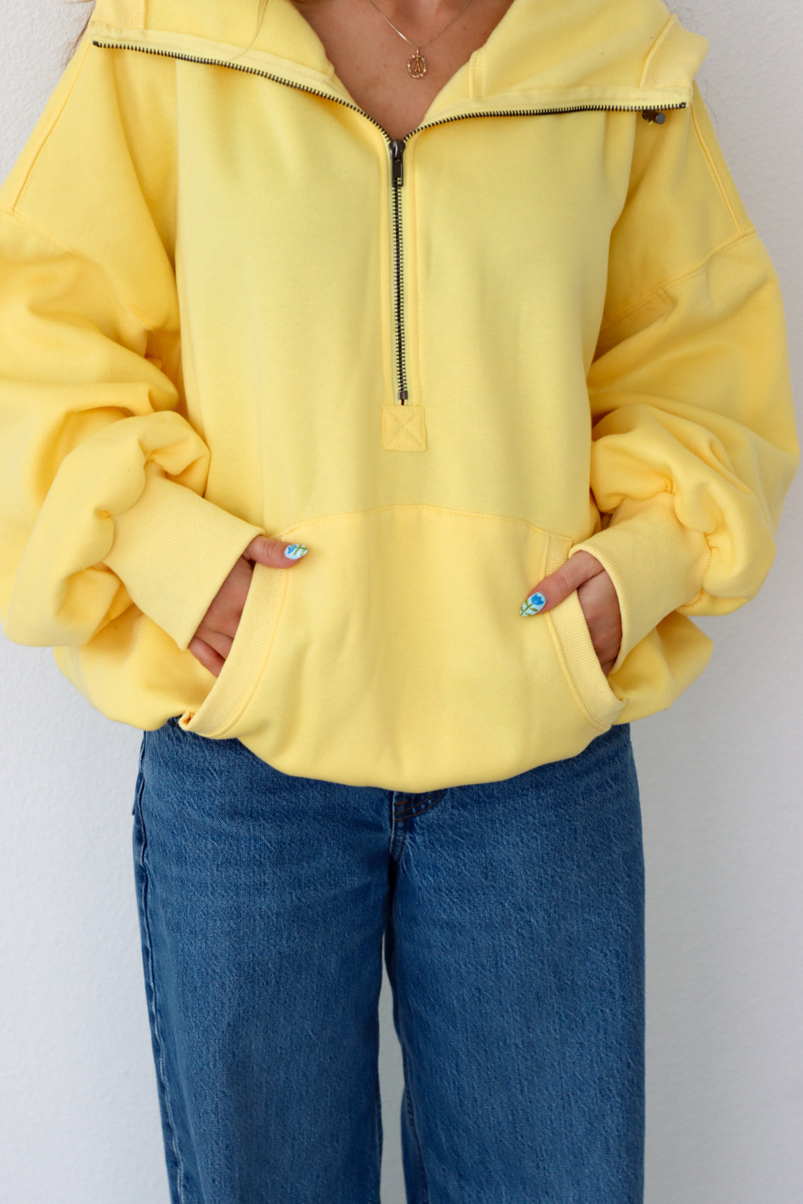 Person wearing a yellow jacket and blue jeans against a white background