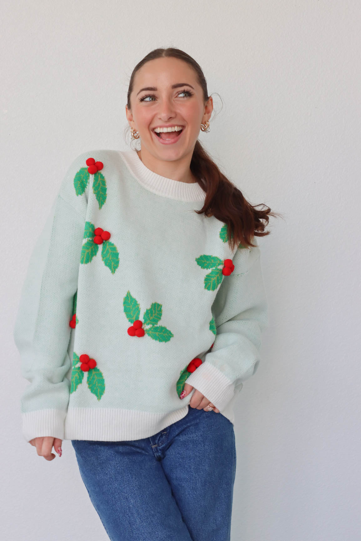 girl wearing white and green holly sweater