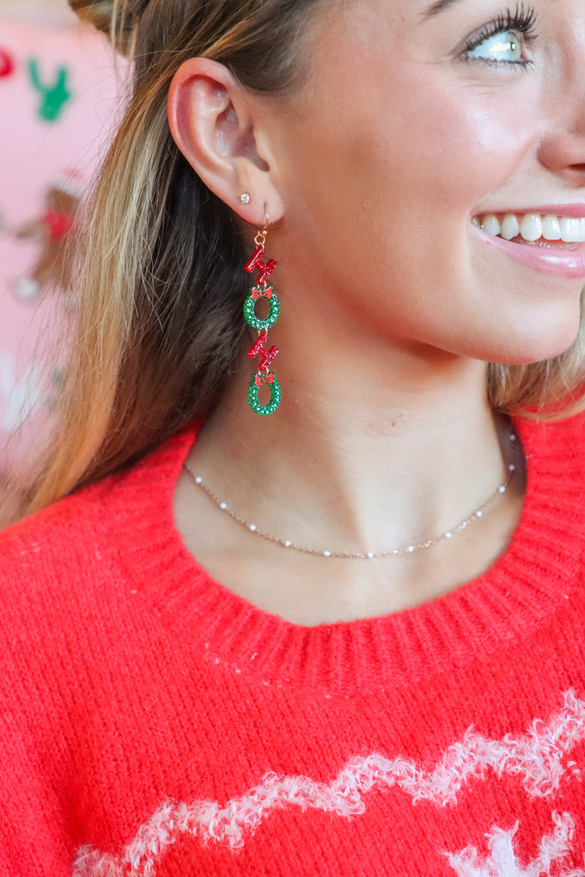 girl wearing red and green "ho ho ho" earrings