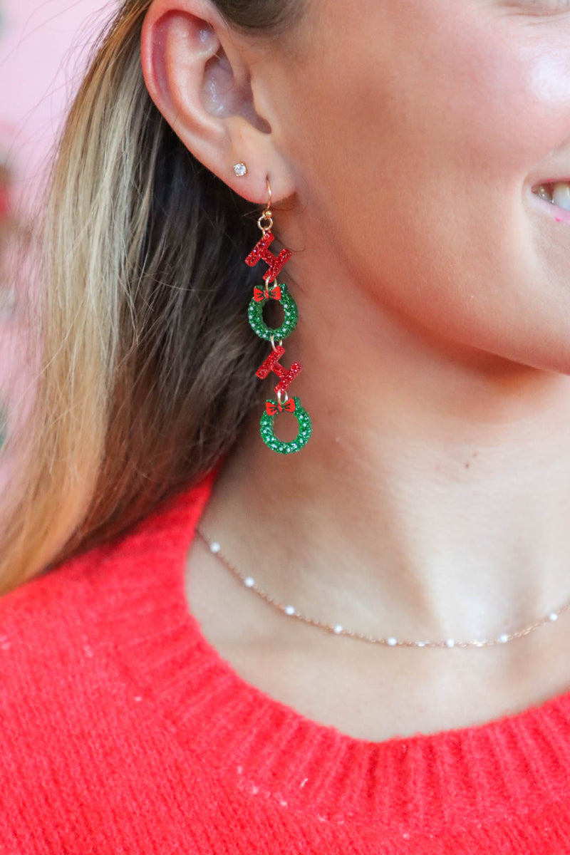 girl wearing red and green "ho ho ho" earrings