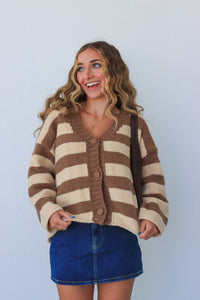 Woman wearing a brown and beige striped sweater against a light blue background