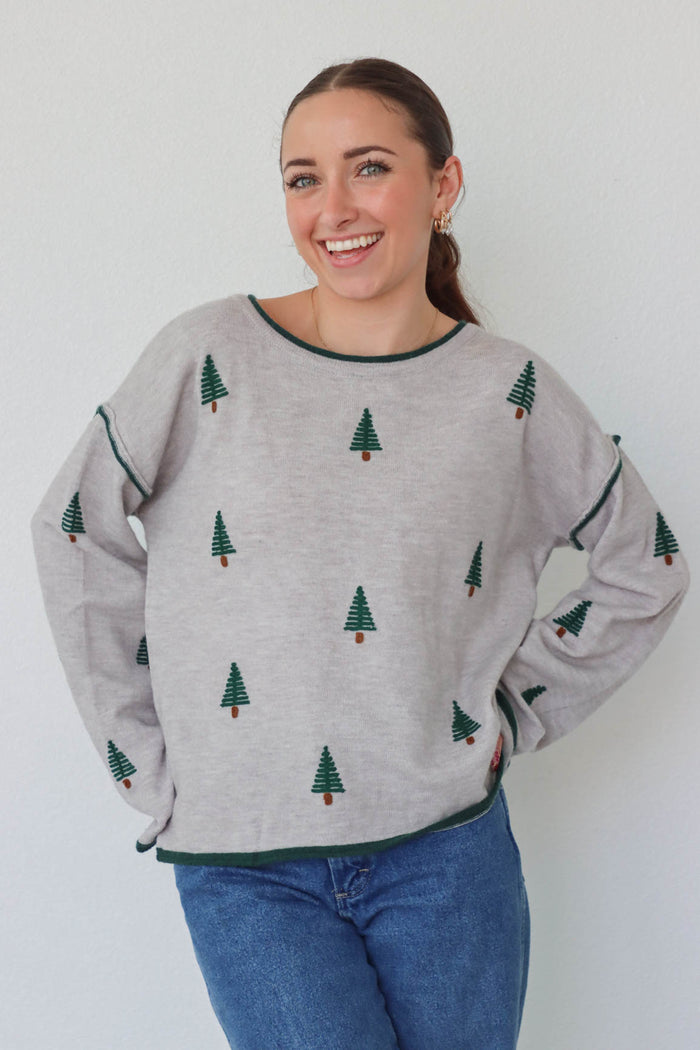 girl wearing gray pine tree sweater