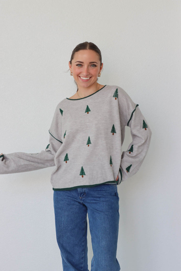 girl wearing gray pine tree sweater