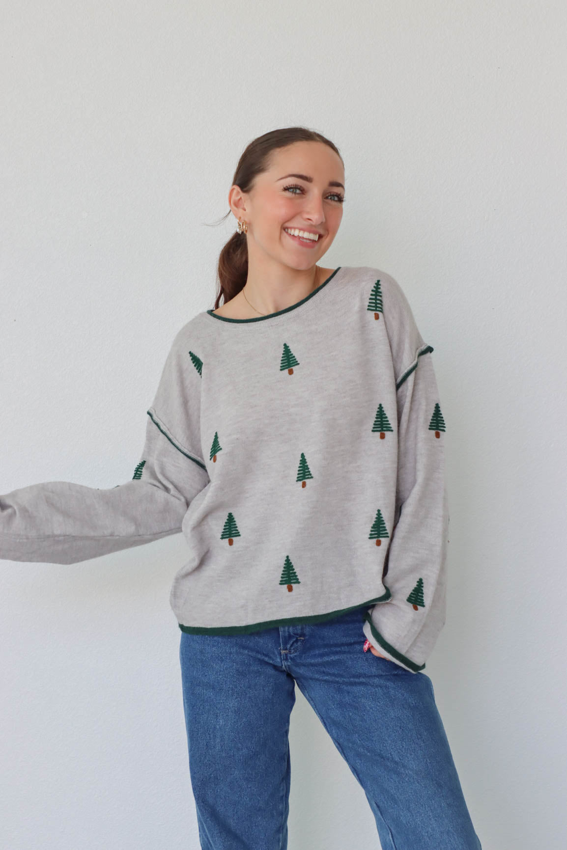 girl wearing gray pine tree sweater