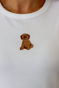 White shirt with a brown embroidered dog design on a plain background