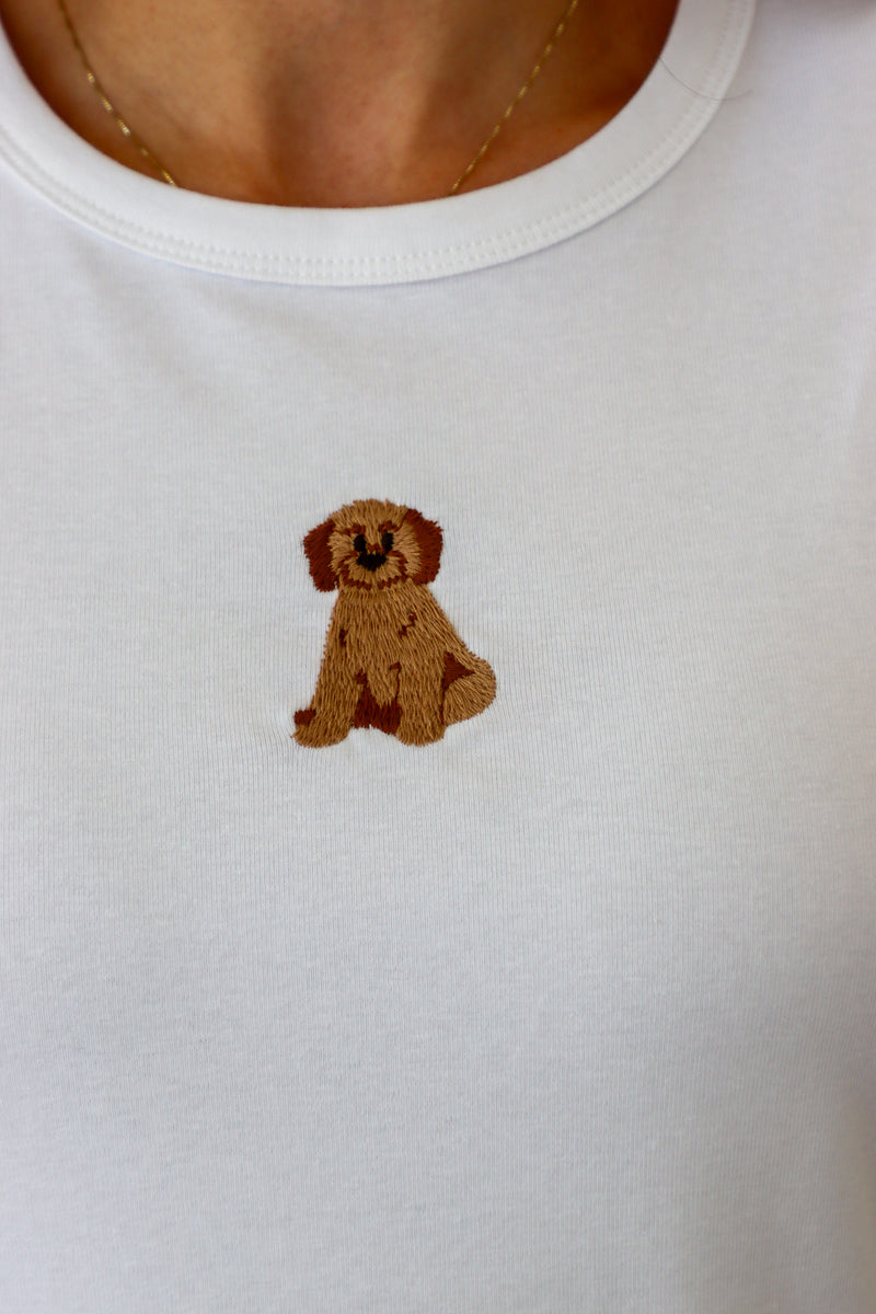 White shirt with a brown embroidered dog design on a plain background