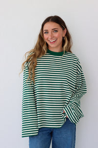 Woman wearing a green and white striped shirt against a white background
