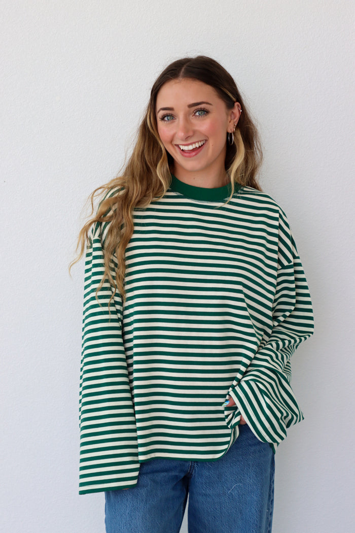 Woman wearing a green and white striped shirt against a white background