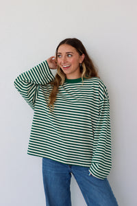 Woman wearing a green and white striped shirt against a white background