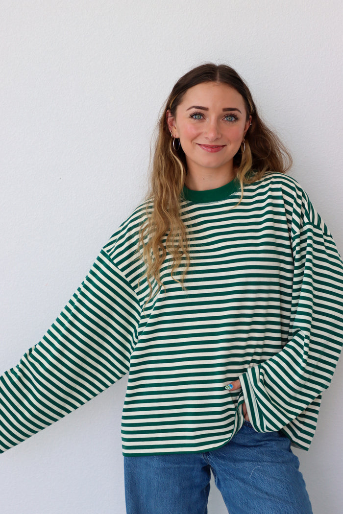 Person wearing a green and white striped shirt against a white background