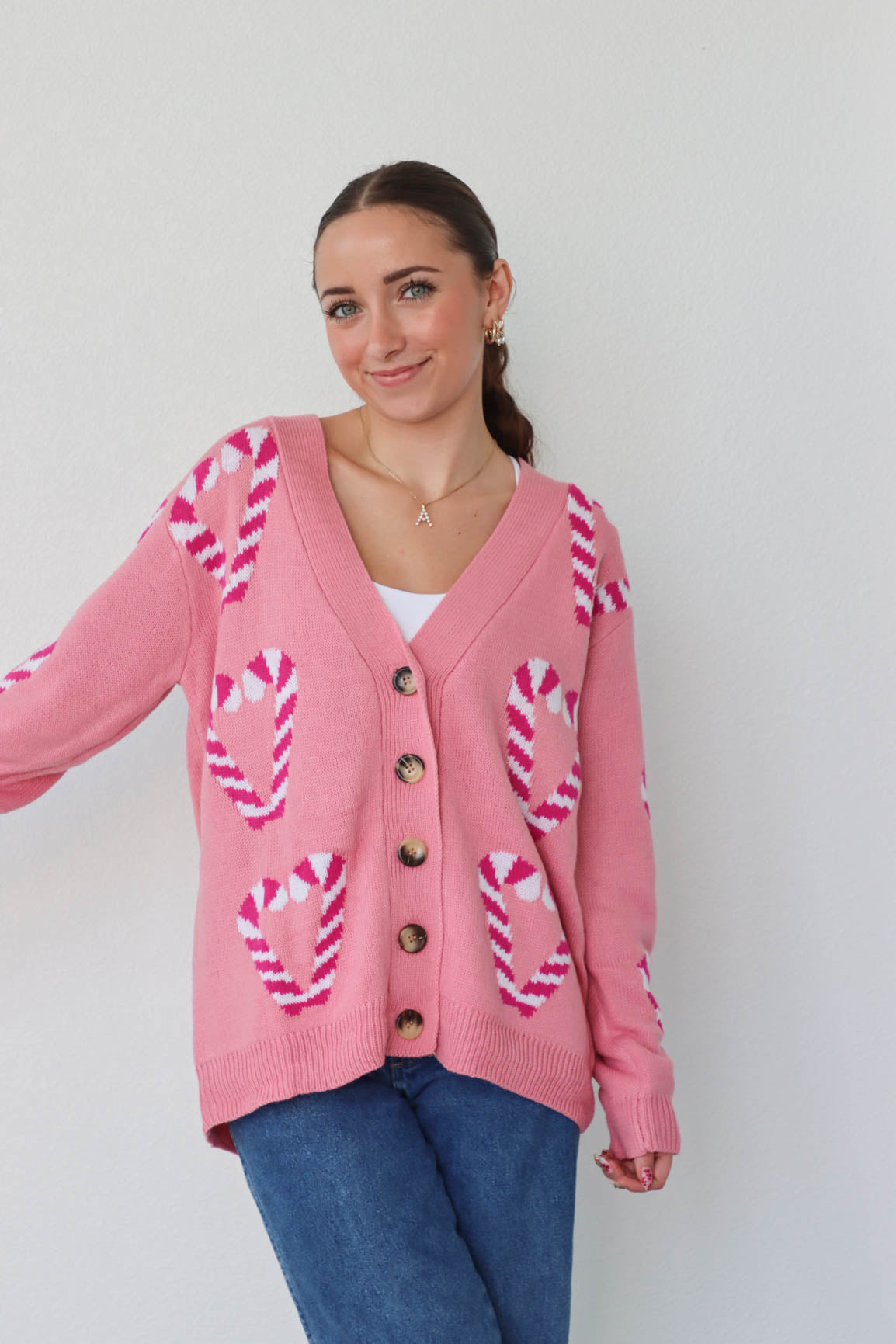 girl wearing pink candy cane cardigan