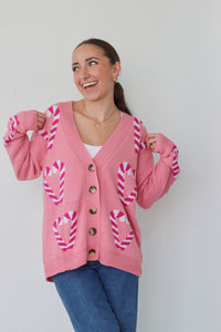 girl wearing pink candy cane cardigan