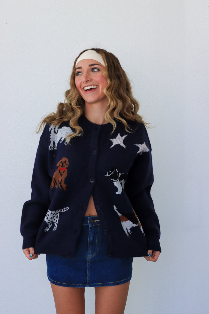 Woman wearing a black cardigan with animal patterns against a white background