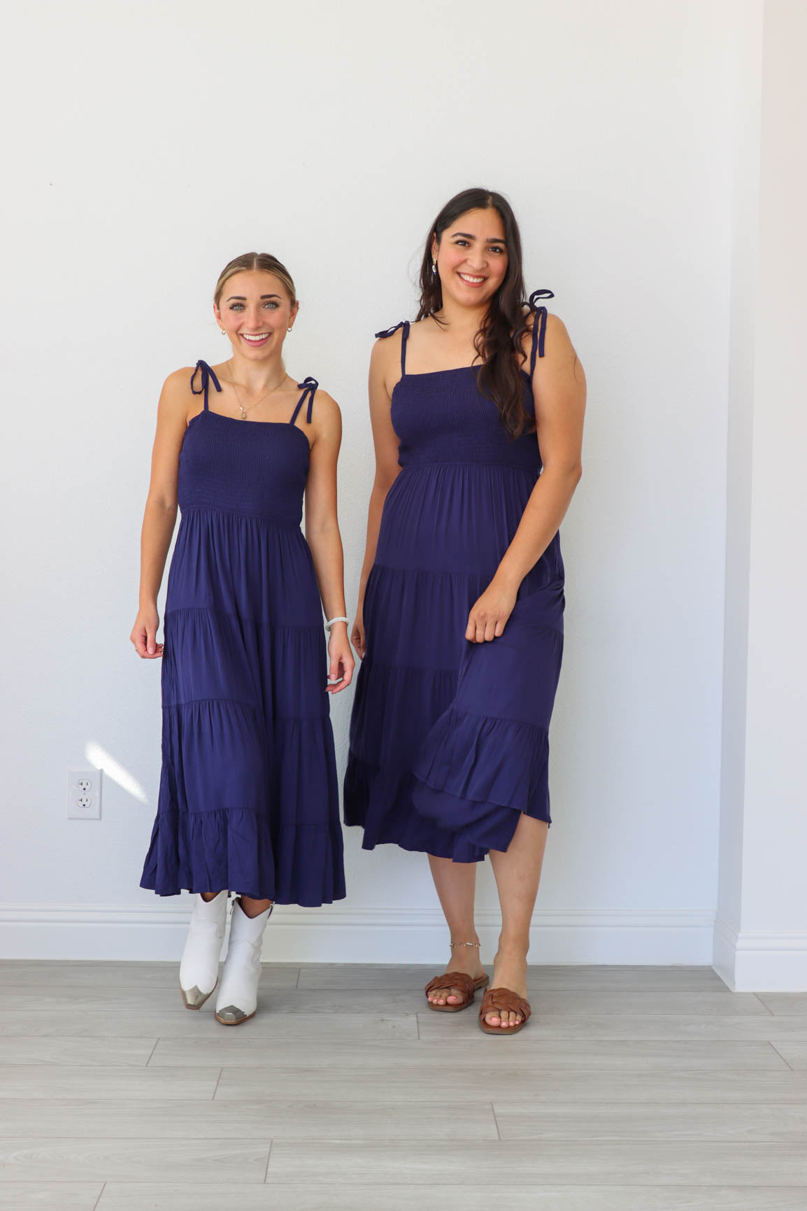 two girls wearing the same navy blue midi dress