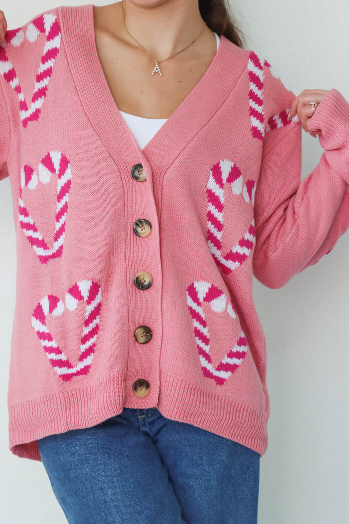 girl wearing pink candy cane cardigan